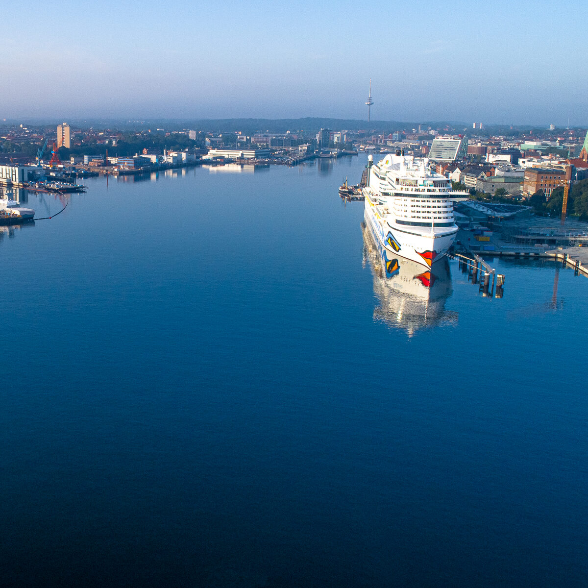 Luftaufnahme der Kieler Förde mit Hafen und einem Kreuzfahrtschiff